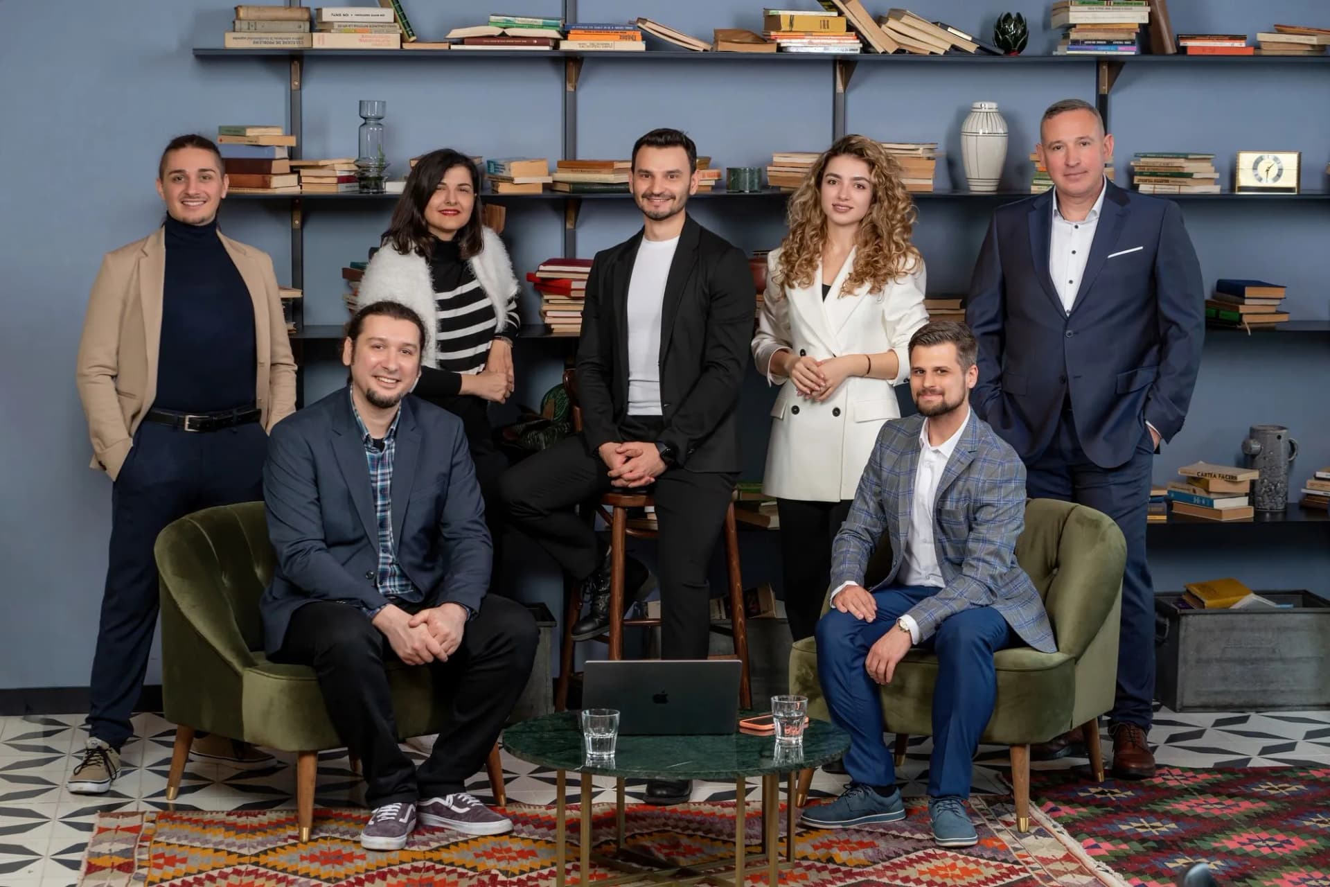 The seven-person Vatis Tech team posed in front of a bookshelf in their office