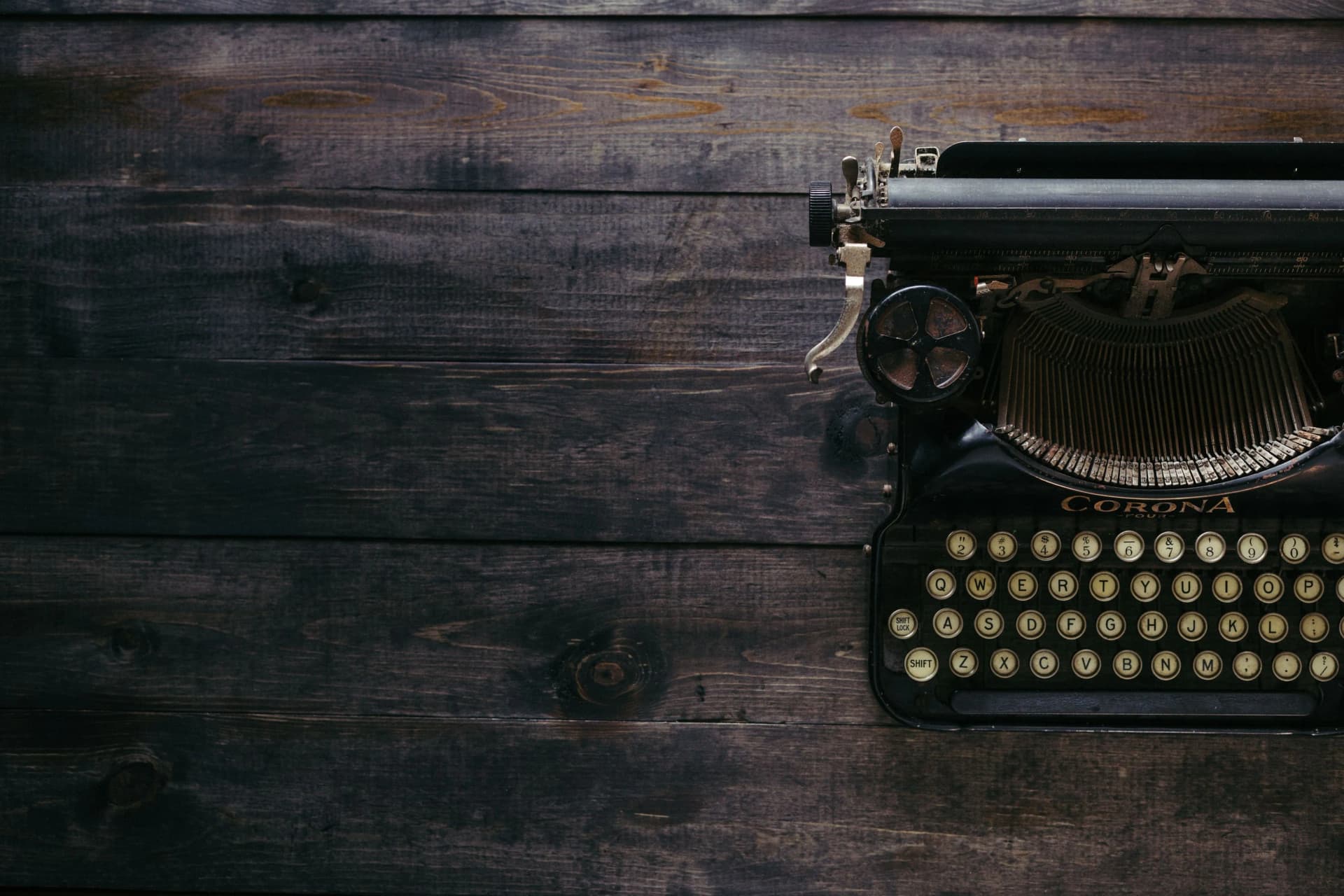 Vintage Corona typewriter photographed from above on dark wooden planks